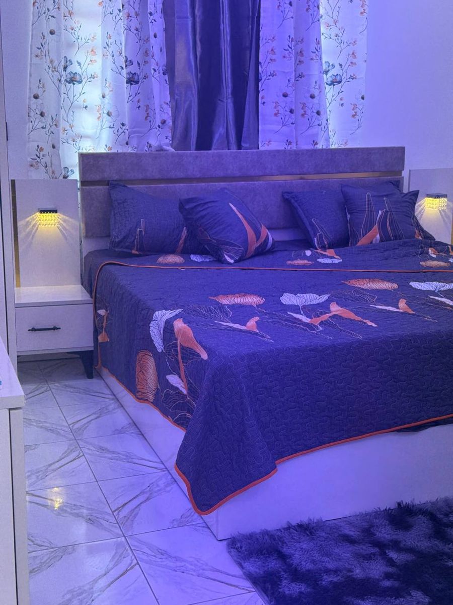 Bed with patterned bedspread and rug