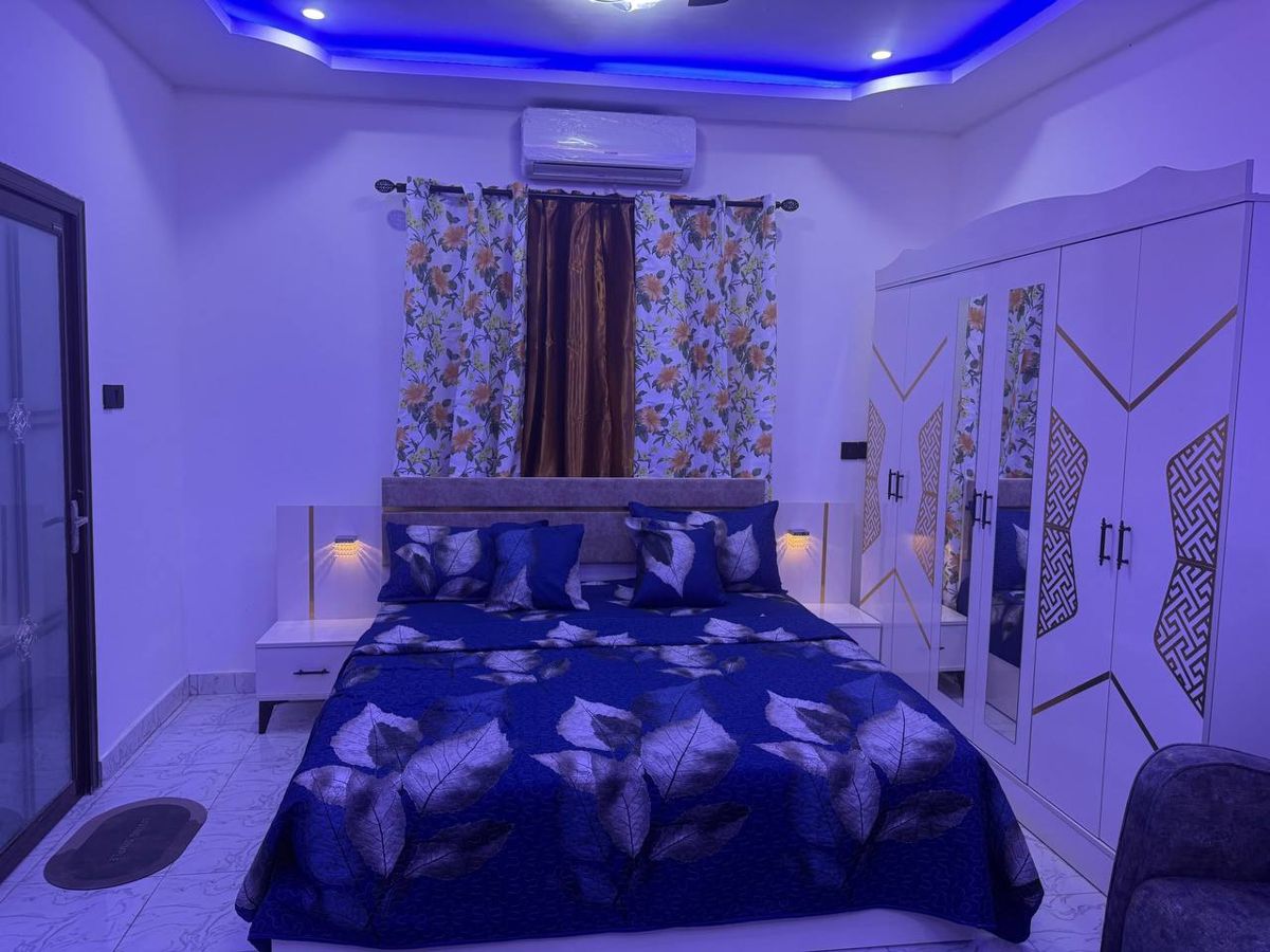 Bedroom with blue bedding and mirrored wardrobe